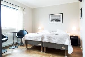 a bedroom with a bed and a desk and a chair at Lokus Hotell in Lysekil