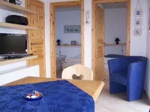 a living room with a table and a blue chair at Bungalow Ungers Welt 1 in Ostseebad Nienhagen