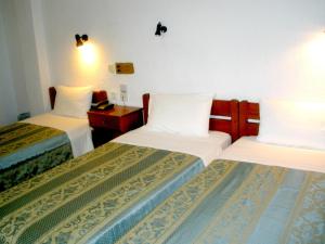 a hotel room with two beds with white sheets at Afroditi in Panormos Skopelos