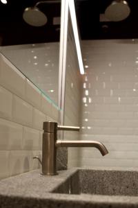 a sink with a faucet in a bathroom at OFFICINA TESINI Guest Rooms Verona in Verona +29 photos