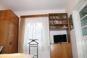a room with a window with a curtain and a tv at Pensiunea Alecsandra in Vatra Dornei