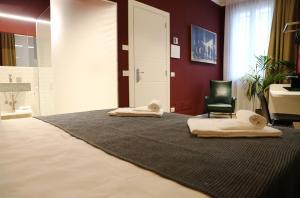 a bedroom with a bed with two towels on it at OFFICINA TESINI Guest Rooms Verona in Verona