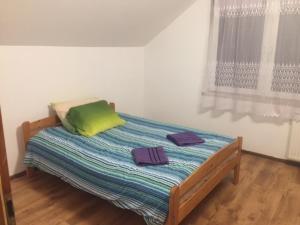 ビェルスコ・ビャワにあるHostel Zgrabnaのベッドルーム1室(ベッド1台、タオル2枚付)