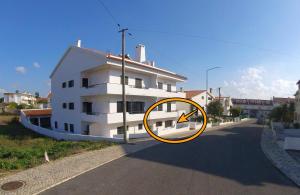 un bâtiment blanc sur le côté d'une route dans l'établissement Studio Martins, à Praia da Areia Branca