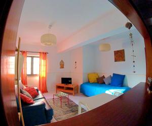 ein Wohnzimmer mit einem blauen Sofa und einem Tisch in der Unterkunft Studio Martins in Praia da Areia Branca