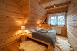 a bedroom with a bed in a log cabin at ZAKOPIANA in Zakopane