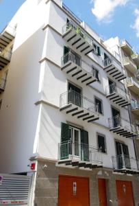 - un bâtiment blanc avec des portes et des balcons verts dans l'établissement BB 10 Serpotta & Restaurant, à Palerme