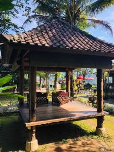 a wooden gazebo with a roof on top of it at Mahagiri Resort & Restaurant in Menanga