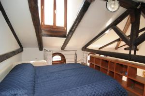 een slaapkamer met een blauw bed op een zolder bij Sunny Canal a/c wifi in Venetië