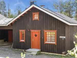 a brown house with a red door and windows at Holiday Home Immelkotsa 7 e by Interhome in Levi