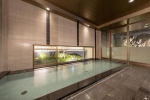 名古屋的住宿－Nishitetsu Hotel Croom Nagoya，一座有窗户的建筑中的空游泳池