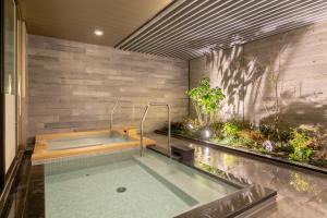 名古屋的住宿－Nishitetsu Hotel Croom Nagoya，一座房子内带热水浴池的游泳池