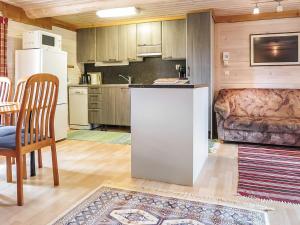 KyröにあるHoliday Home Ruska by Interhomeのキッチン(冷蔵庫、テーブル、椅子付)