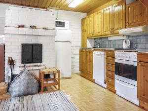 eine Küche mit Holzschränken und weißen Geräten in der Unterkunft Holiday Home Luppo by Interhome in Kyrö