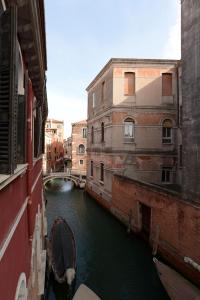 威尼斯的住宿－Sunny Canal a/c wifi，两栋建筑之间的运河上的船