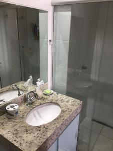 y baño con lavabo y ducha. en Everest Flat Service, en Caldas Novas