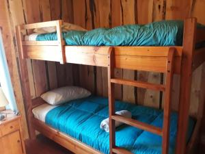 Una cama o camas en una habitación de Cabañas el arrayan neltume