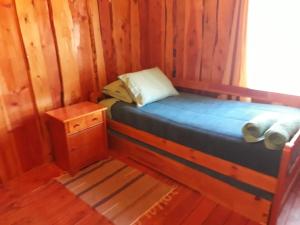 Una cama o camas en una habitación de Cabañas el arrayan neltume