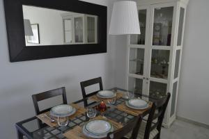 een eetkamer met een tafel met stoelen en een spiegel bij Apartamento Cabo de Gata in Retamar
