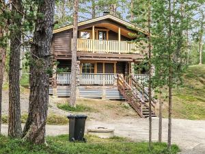 a log cabin in the woods with a trash can in front of it at Holiday Home Ruska by Interhome in Kyrö