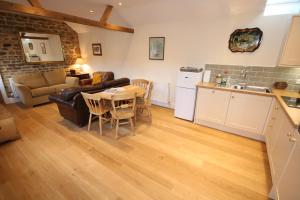 cocina y sala de estar con sofá y mesa en Bolton's Cottage, en Oakham