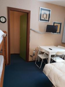 Zimmer mit einem Schreibtisch, einem Tisch und einem Bett in der Unterkunft Val di Luce-Foemina 78 in Abetone