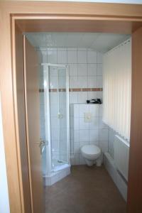 uma casa de banho com um chuveiro e um WC. em Hotel Bad Griepshop em Hille
