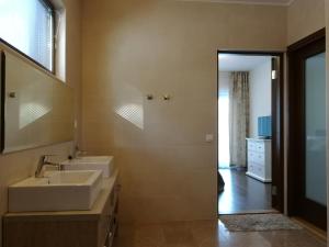 Baño con 2 lavabos y espejo en Marina Holiday Rauhan Village Apartments, en Imatra