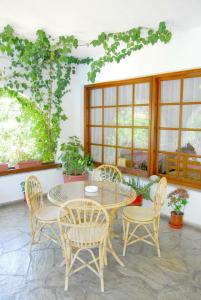 a patio with a table and chairs and windows at Afroditi in Panormos Skopelos