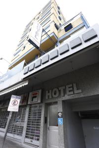 a hotel building with a sign in front of it at Hotel Paraiso in Santa Maria