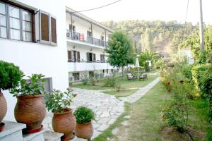 a garden with potted plants on the side of a building at Afroditi in Panormos Skopelos