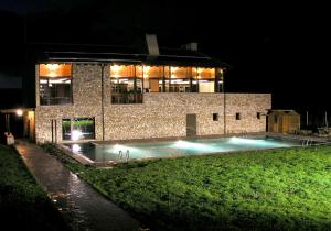 a building with a swimming pool in front of it at night at Hotel Rural y SPA Kinedomus Bienestar in Aranda de Duero