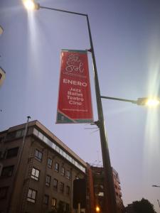 un cartel en un poste de la calle con un edificio en Lindo departamento a pasos del Centro comercial Costanera Center, en Santiago