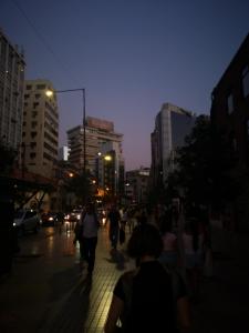 grupa ludzi idących nocą ulicą miasta w obiekcie Lindo departamento a pasos del Centro comercial Costanera Center w mieście Santiago