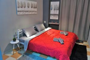 a bedroom with a red bed with a red blanket at Arch of Galerius Studio (Καμάρα) in Thessaloniki