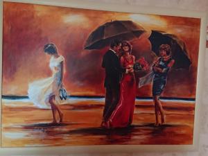 a painting of a couple with umbrellas at Ferienhaus Wieke in Wiesmoor