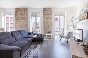 Una sala de estar con un sofá y un televisor. en Travel Habitat Ruzafa Apartment, en Valencia
