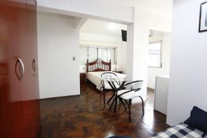 een kamer met een tafel en stoelen en een bed bij Hotel Paraiso in Santa Maria
