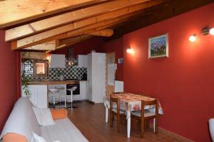 a living room with a table and a kitchen at Casa Chiocciola CIPAT O22138-AT-O66928 in Pelugo