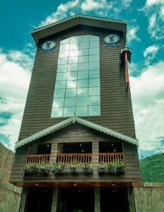 ein hohes Gebäude mit einem Uhrturm mit Fenstern in der Unterkunft Tin Tin Boutique Bijanbari in Darjeeling