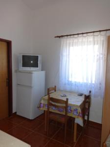 a table and chairs with a table and a microwave at Apartments Palma in Vir