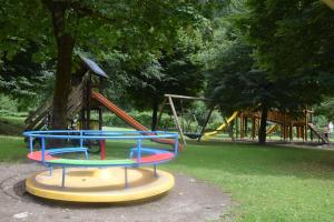 a park with a playground with a slide and swings at Casa Chiocciola CIPAT O22138-AT-O66928 in Pelugo