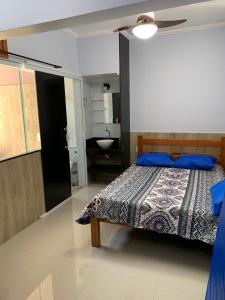 um quarto com uma cama e uma casa de banho com um lavatório em CASA PÔR DO SOL 1 em Arraial do Cabo