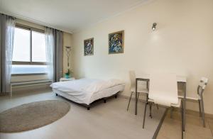a bedroom with a bed and a table and chairs at Sea View Beach Apartment in Haifa