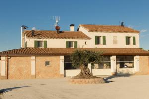a building with a tree in front of it at Agriturismo Le margherite in Cesenatico