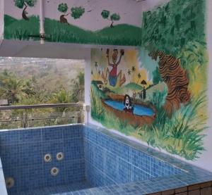 a bathroom with a mural of a zebra and a river at Ocean Shores Hospitality in Candolim