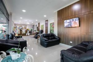 sala de estar con muebles negros y TV de pantalla plana en Hotel Trevita Foz en Foz de Iguazú