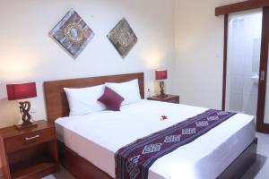 una camera con un grande letto e una doccia di Sekar Waru Homestay a Sanur