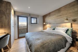 - une chambre avec un grand lit et un mur en bois dans l'établissement Chalet Caprice, à Combloux