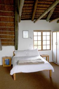 una camera da letto con un grande letto con lenzuola bianche di Arniston Seaside Cottages a Arniston